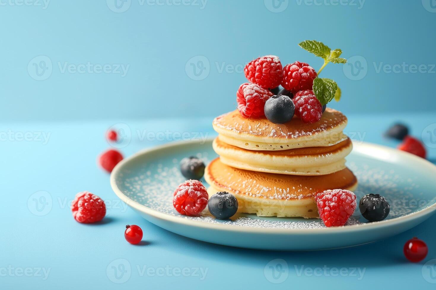Stack of freshly made pancakes topped with raspberries and blueberries, dusted with powdered sugar, perfect for Shrove Tuesday or brunch concepts photo