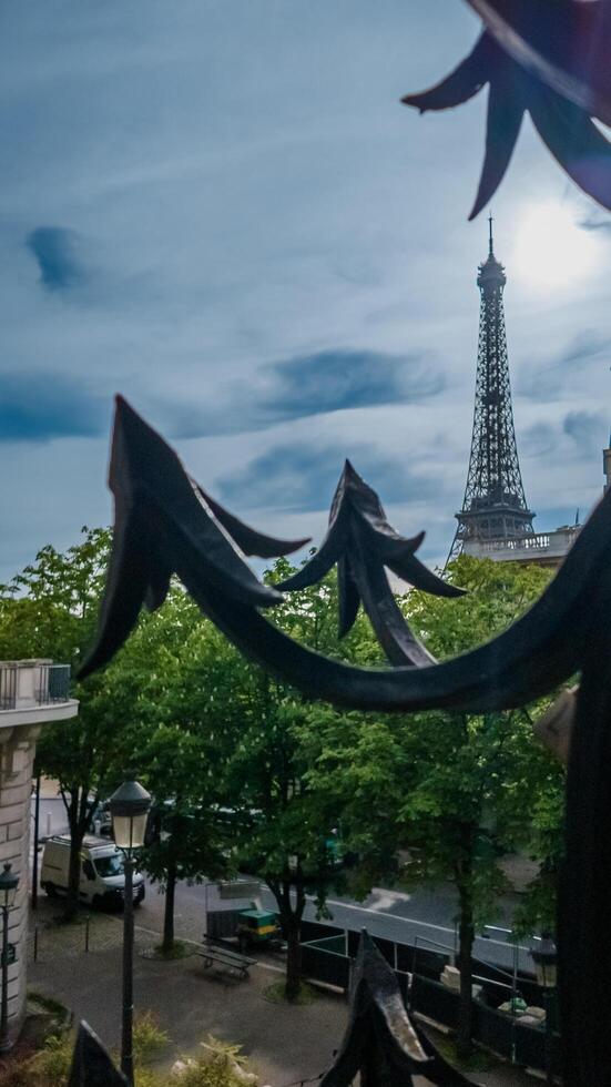 Eiffel Tower viewed through ornate iron fence, capturing the essence of Parisian spring, photographed in Paris, France, on April 14th, 2024, ideal for travel themes photo