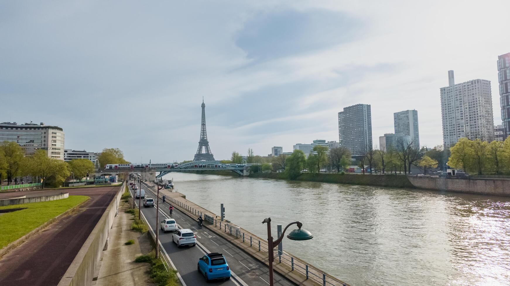 Scenic view of the Eiffel Tower and Seine River amidst cityscape in Paris, France, on April 14th, 2024, ideal for travel and Bastille Day themes photo