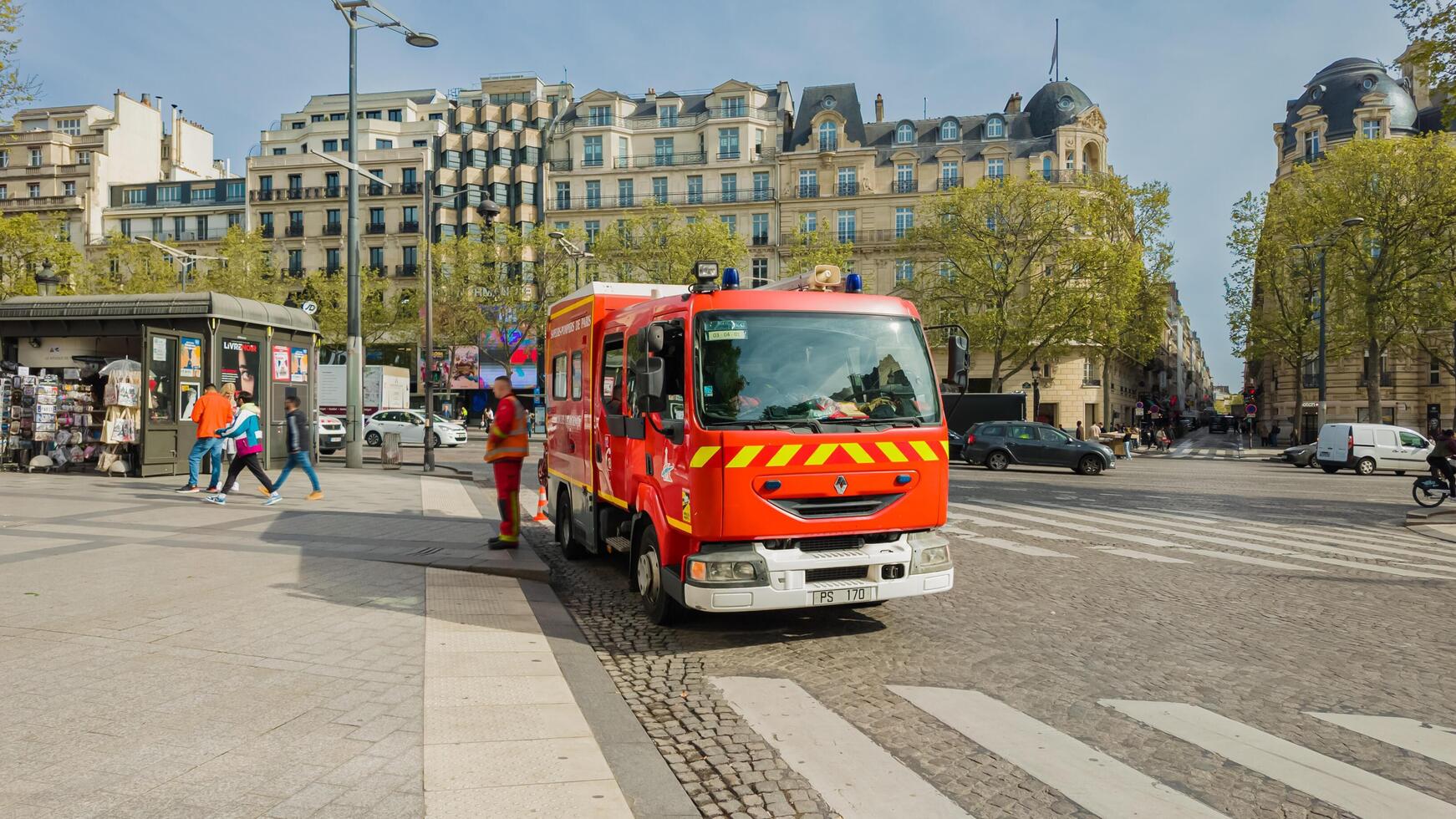 rojo francés fuego motor respondiendo a un emergencia en París, Francia, con peatones y tradicional arquitectura en fondo, abril 14, 2024, urbano la seguridad concepto foto