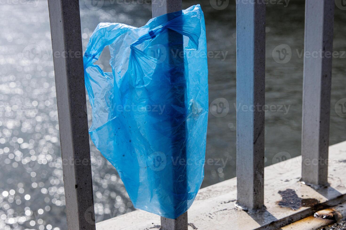 Blue Plastic bag hanging on the railing of Elisabeth bridge over Donau river in Budapest. Garbage in the city. Environmental pollution concept. Ecological disaster, catastrophe. Selective focus photo