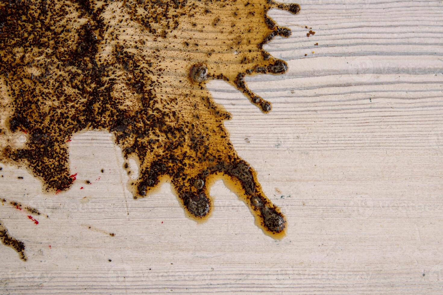 Coffee stains on white wooden table. Wood texture background. Big dark brown dramatic Splatter, fleck, splash, spot, drops of black coffee. Pattern, wallpaper. Top view. Closeup. Copy space. photo