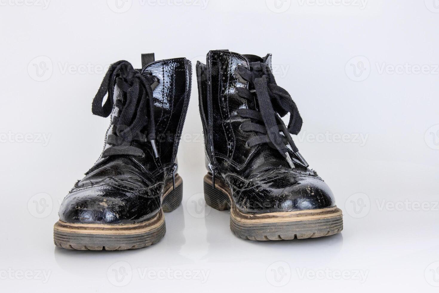 Old used broken Black Leather Army lace Boots. Trendy autumn boots. Stylish womens mens unisex Grunge boots with bootlace. High Military shoes isolated on white background. Flat lay. Copy space photo