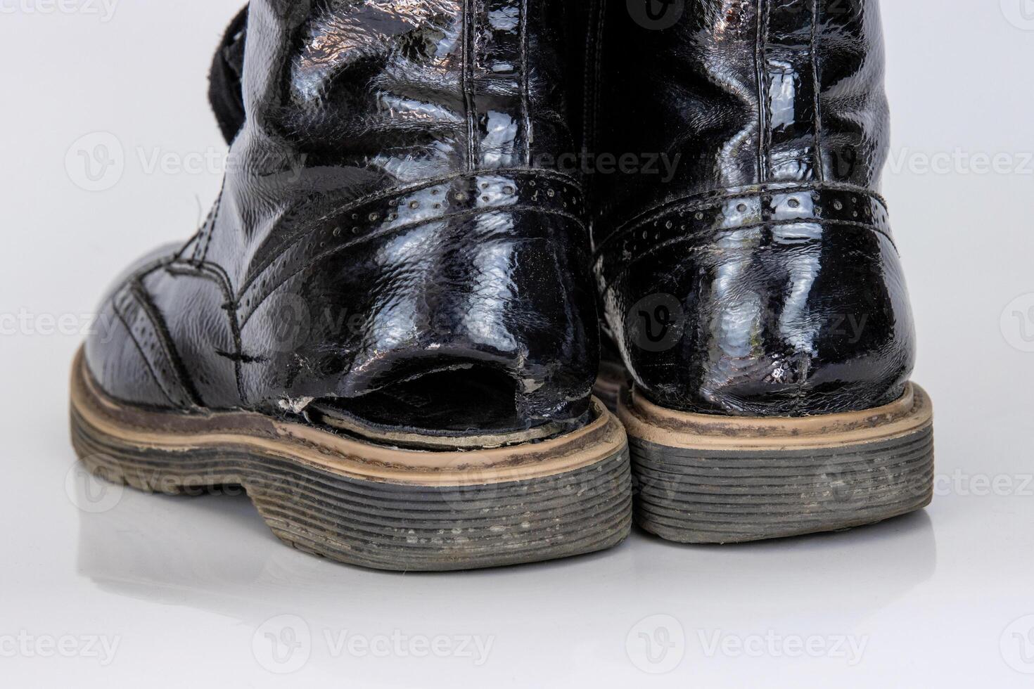 Old used broken Black Leather Army lace Boots. Trendy autumn boots. Stylish womens mens unisex Grunge boots with bootlace. High Military shoes isolated on white background. Flat lay. Copy space photo