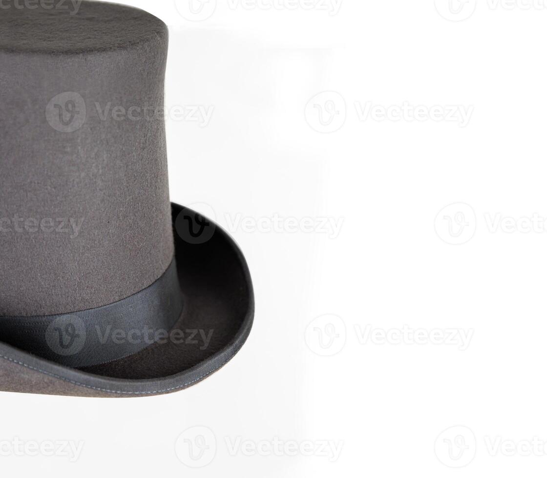 Magic hat. Topper. Elegant vintage gray beige wool felt top hat with black band. Grosgrain ribbon trim around rolled brim. Isolated on white background. Close-up. Copy space. Cut out. Clipping path. photo