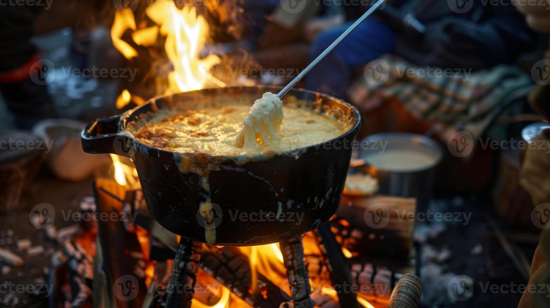 A pot of cheesy bubbling fondue is p in the center of the fire enticing everyone to gather around and dip in photo