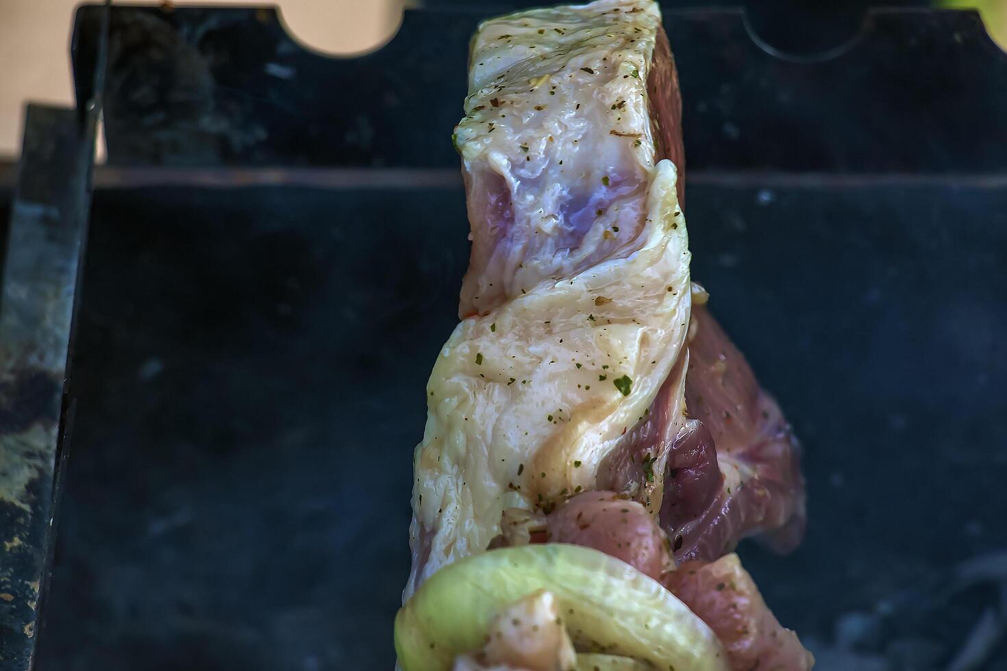 Cooking kebabs on a grill with smoke. Fresh brown BBQ meat cooked on an outdoor grill photo