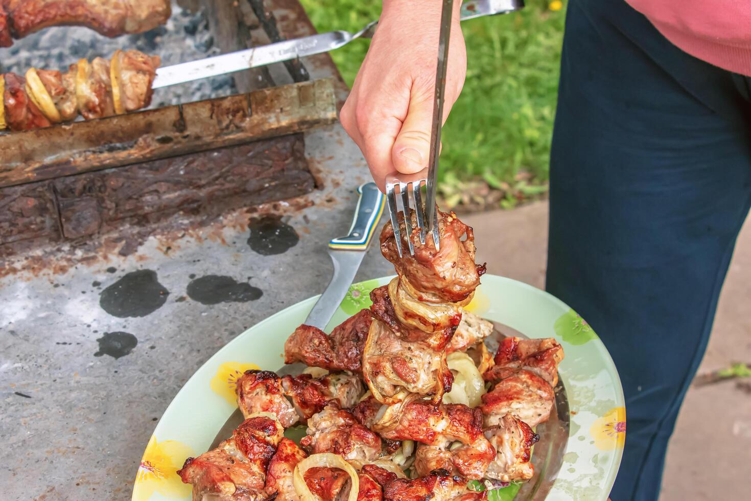 Cooked kebabs on the grill with smoke. Fresh brown BBQ meat cooked on an outdoor grill photo