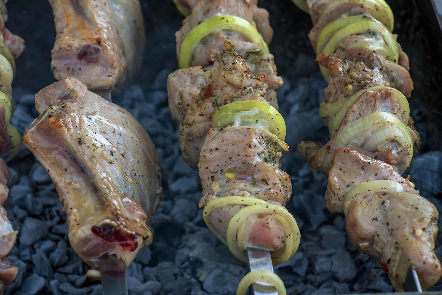 Cooking kebabs on a grill with smoke. Fresh brown BBQ meat cooked on an outdoor grill photo