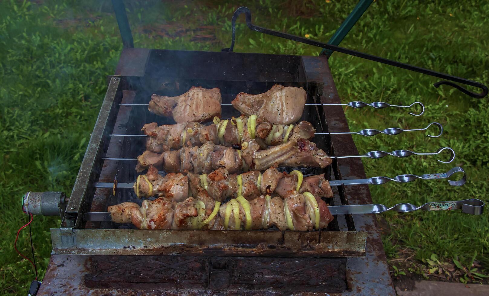 Cooking kebabs on a grill with smoke. Fresh brown BBQ meat cooked on an outdoor grill photo