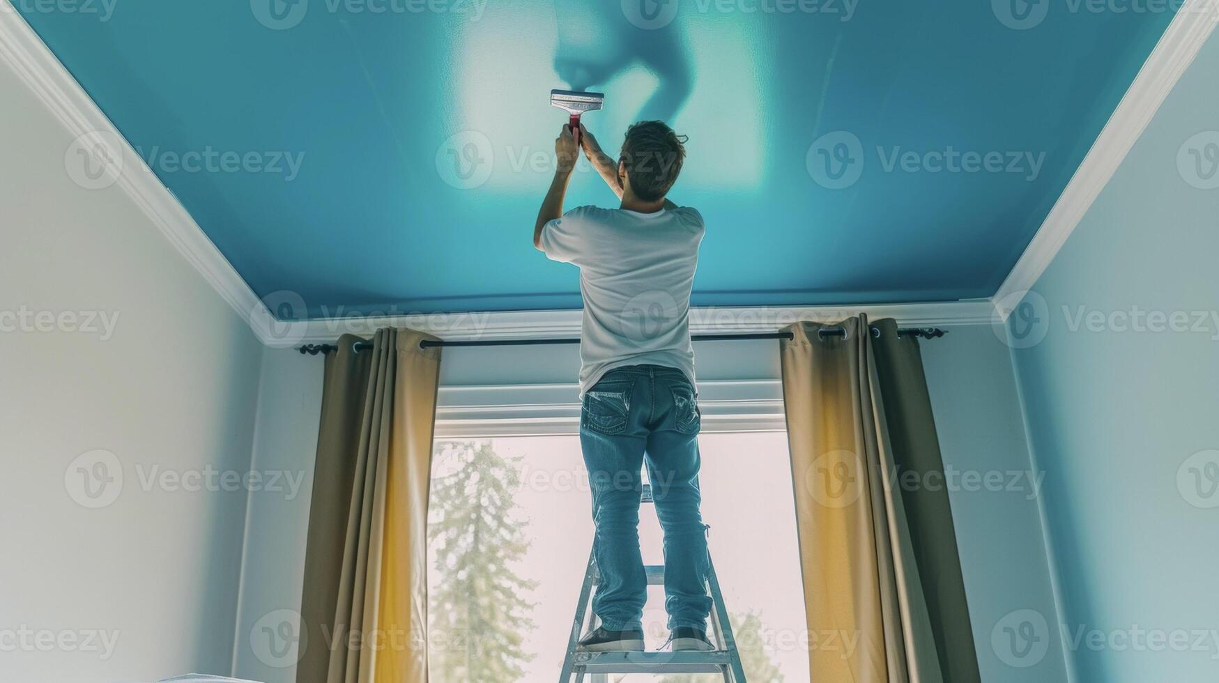 A man stands on a ladder meticulously painting the ceiling of his bedroom in a bold and playful color giving the room a unique and personalized touch photo