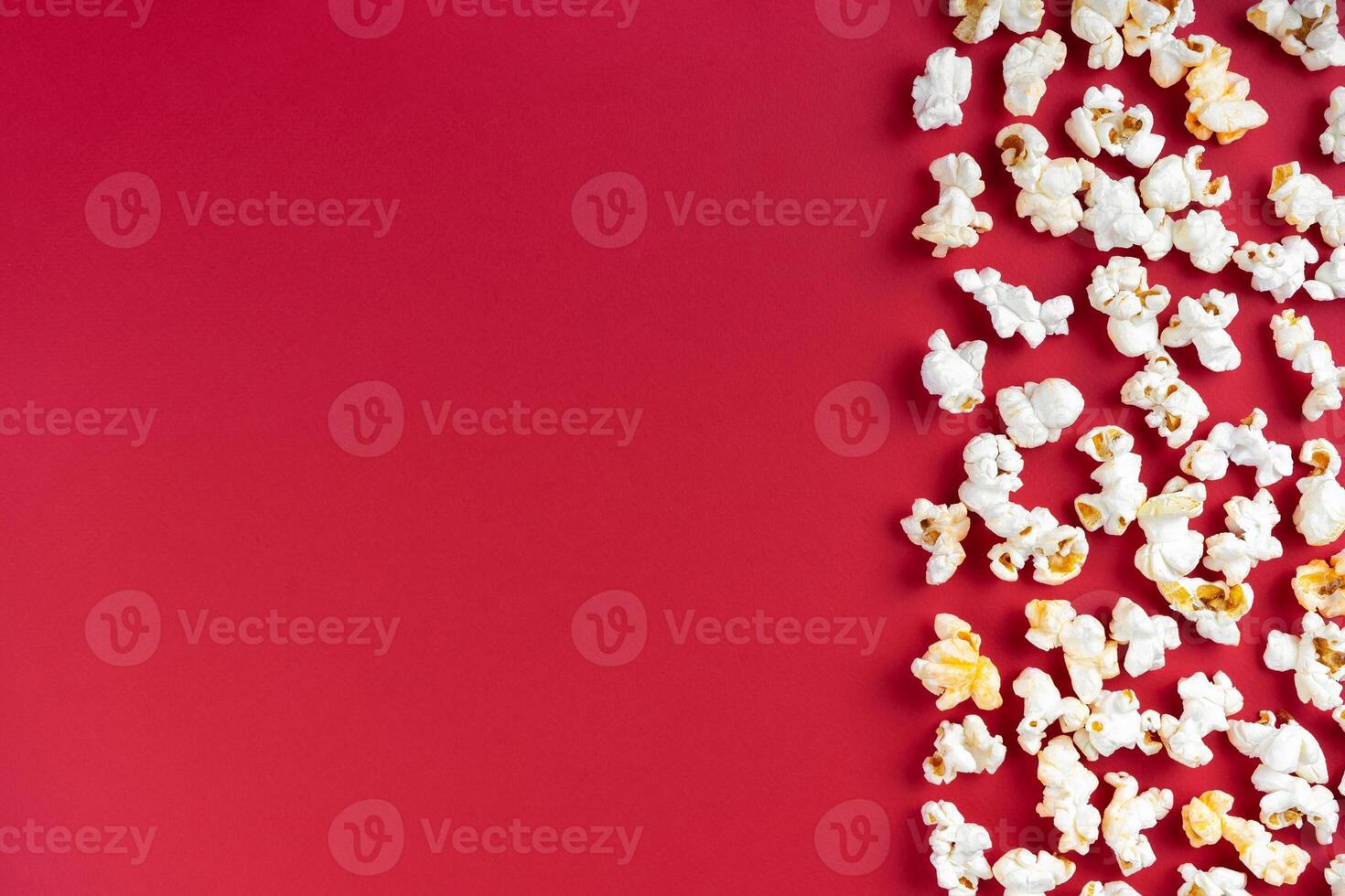 Popcorn pattern, border on red background. Top view, flat lay with copy space photo