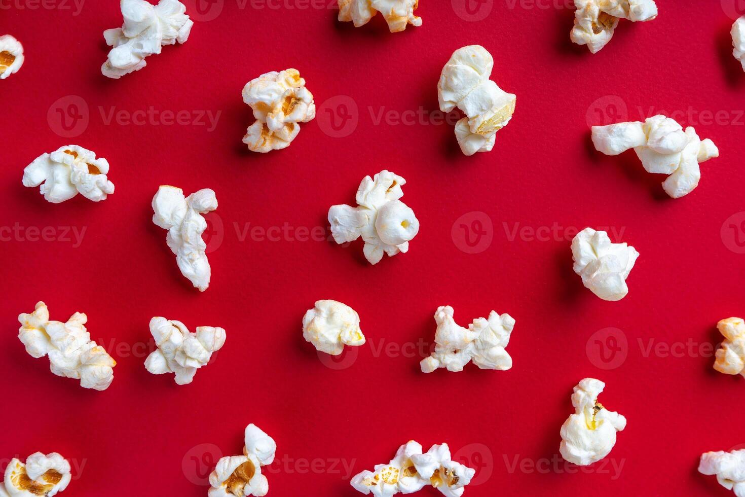 Popcorn pattern on red background. Top view, flat lay photo