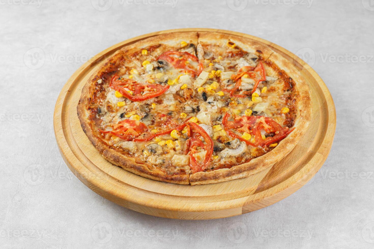 Italian pizza with melted mozzarella cheese mushrooms, corn and tomato on white concrete background photo