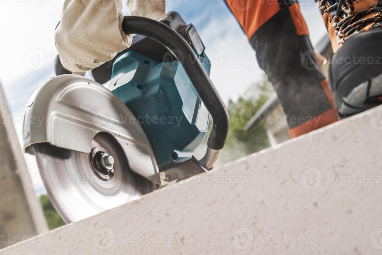 Construction Worker Cutting Concrete Brick Using a Circular Saw photo