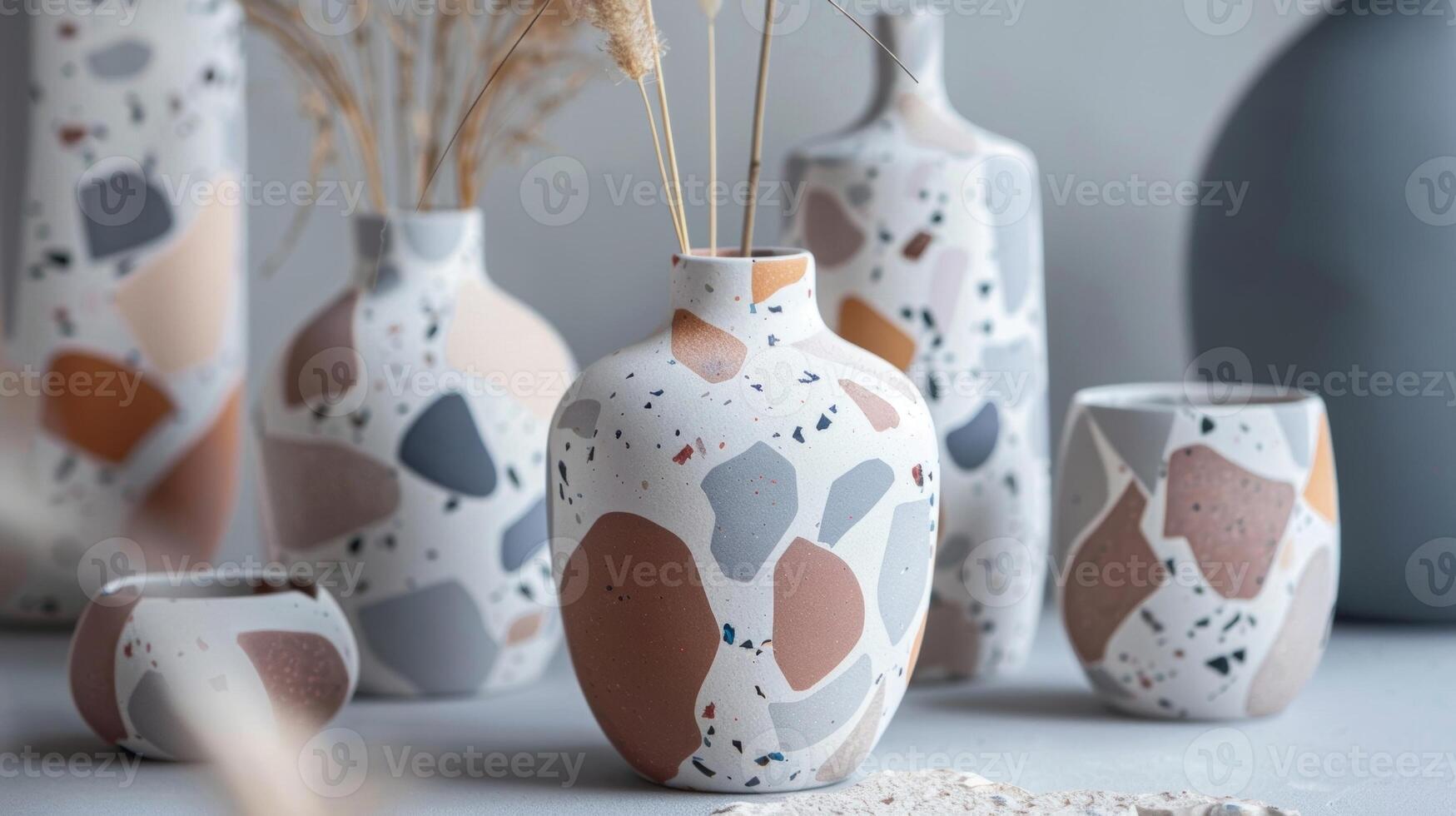 A terracotta vase with a modern twist featuring a terrazzo pattern in shades of grey white and blush pink. photo