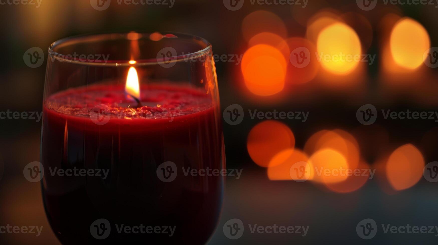 A closeup of a glass filled with a vibrant red juice reflecting the soft glow of candlelight photo