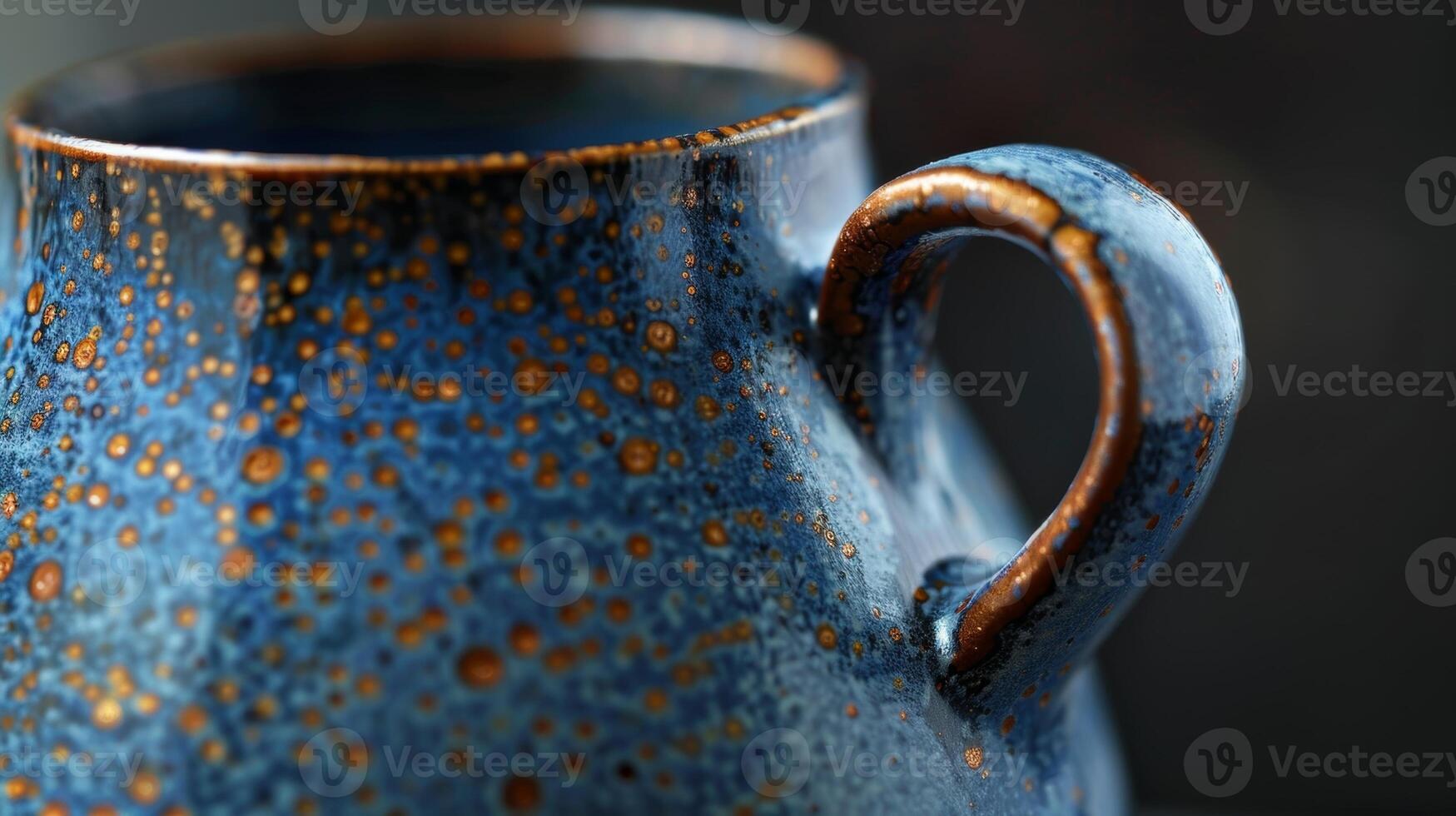 A pitcher with a striking combination of smooth dark blue and speckled bronze glazes showcasing the range of colors possible through soda firing. photo