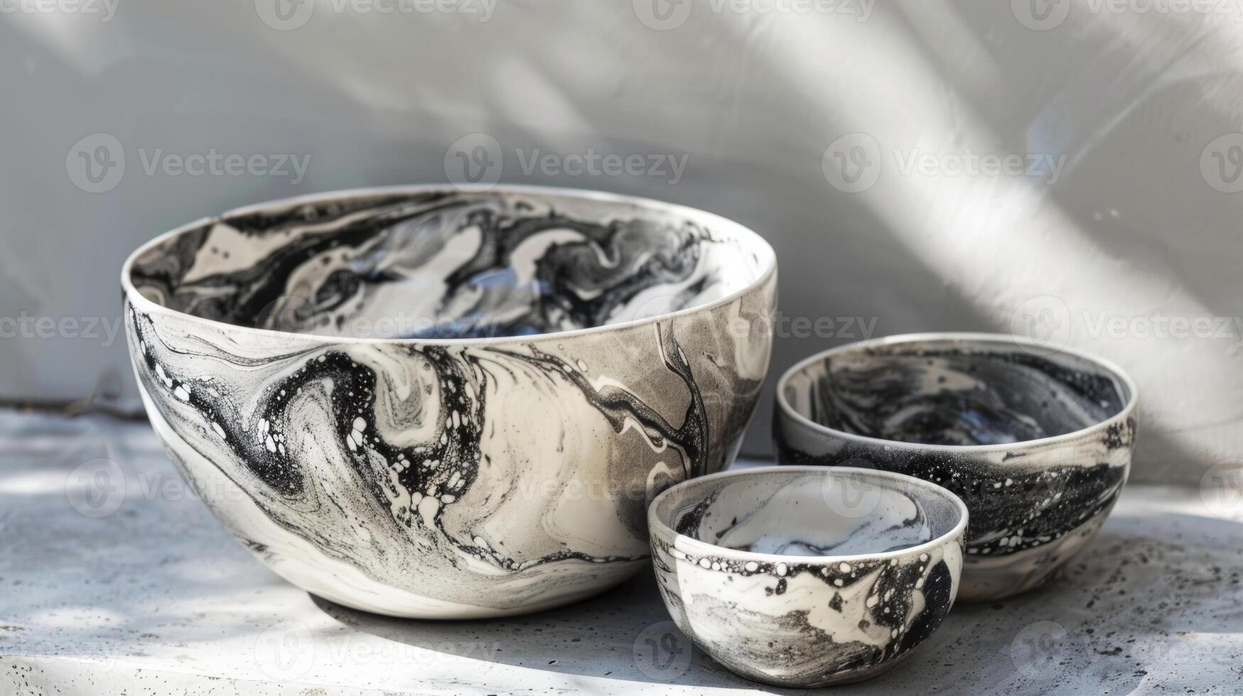 A set of bowls featuring a marbled glaze effect in shades of black and white resembling the texture of marble stone. photo