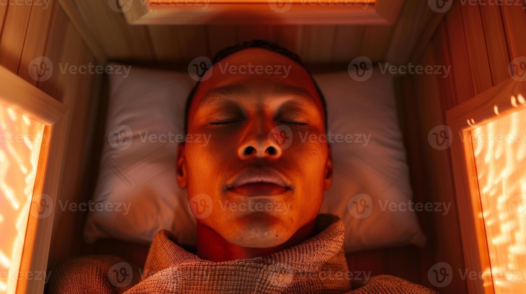 An overhead shot of a persons face visibly relaxed and peaceful as they experience the deep tissue benefits of an infrared sauna session. photo