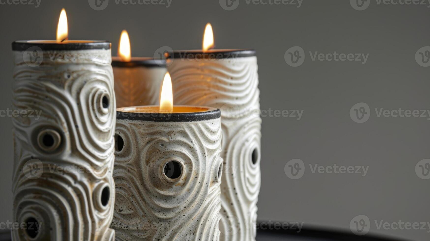 A trio of ceramic candle holders all with their own unique textures of swirls dots and lines making them a stunning addition to any mantelpiece or shelf. photo