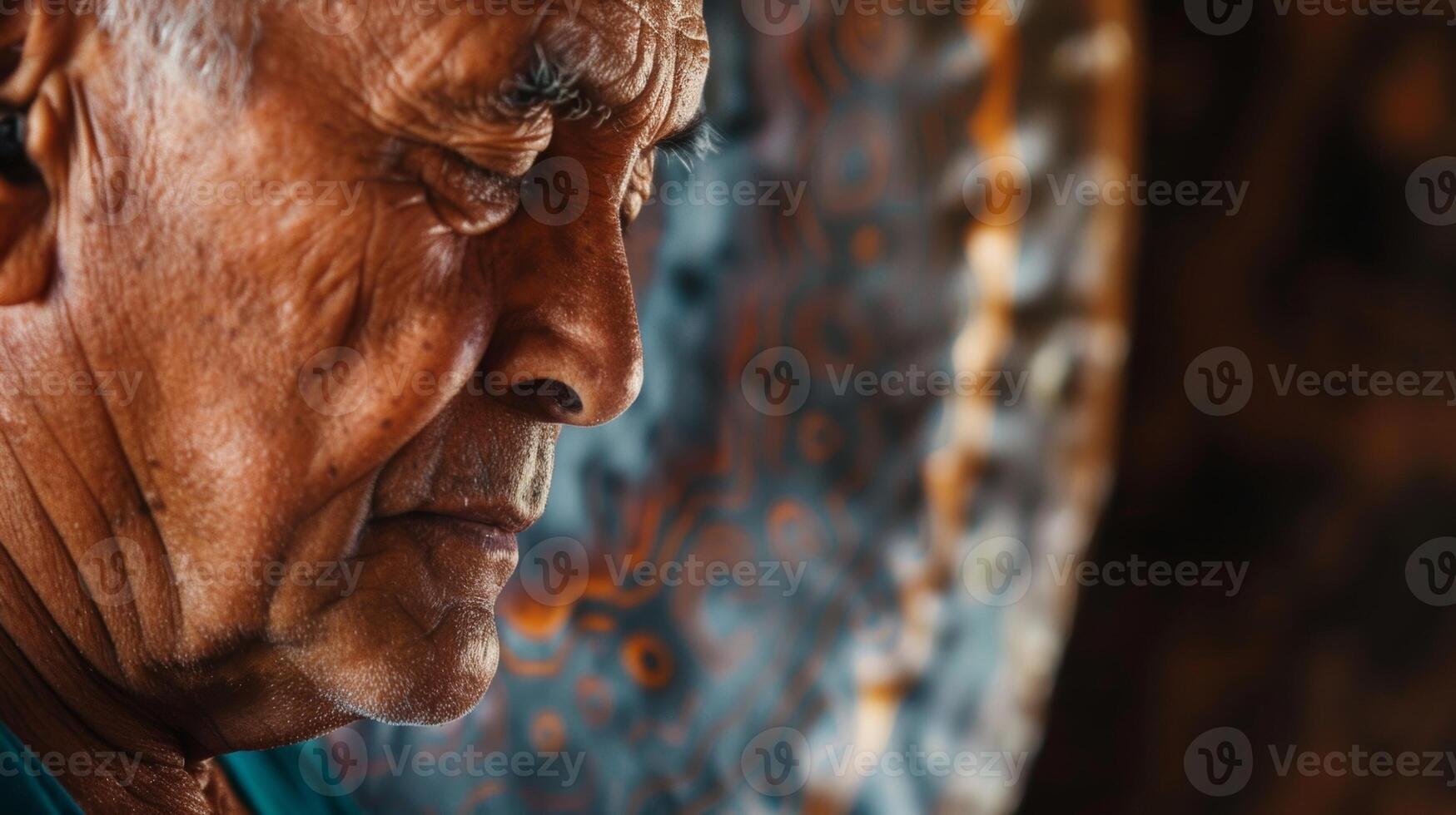 A close up of a mans face his forehead wrinkled as he concentrates on the vibrations and sounds created by a gong during a sound healing session photo