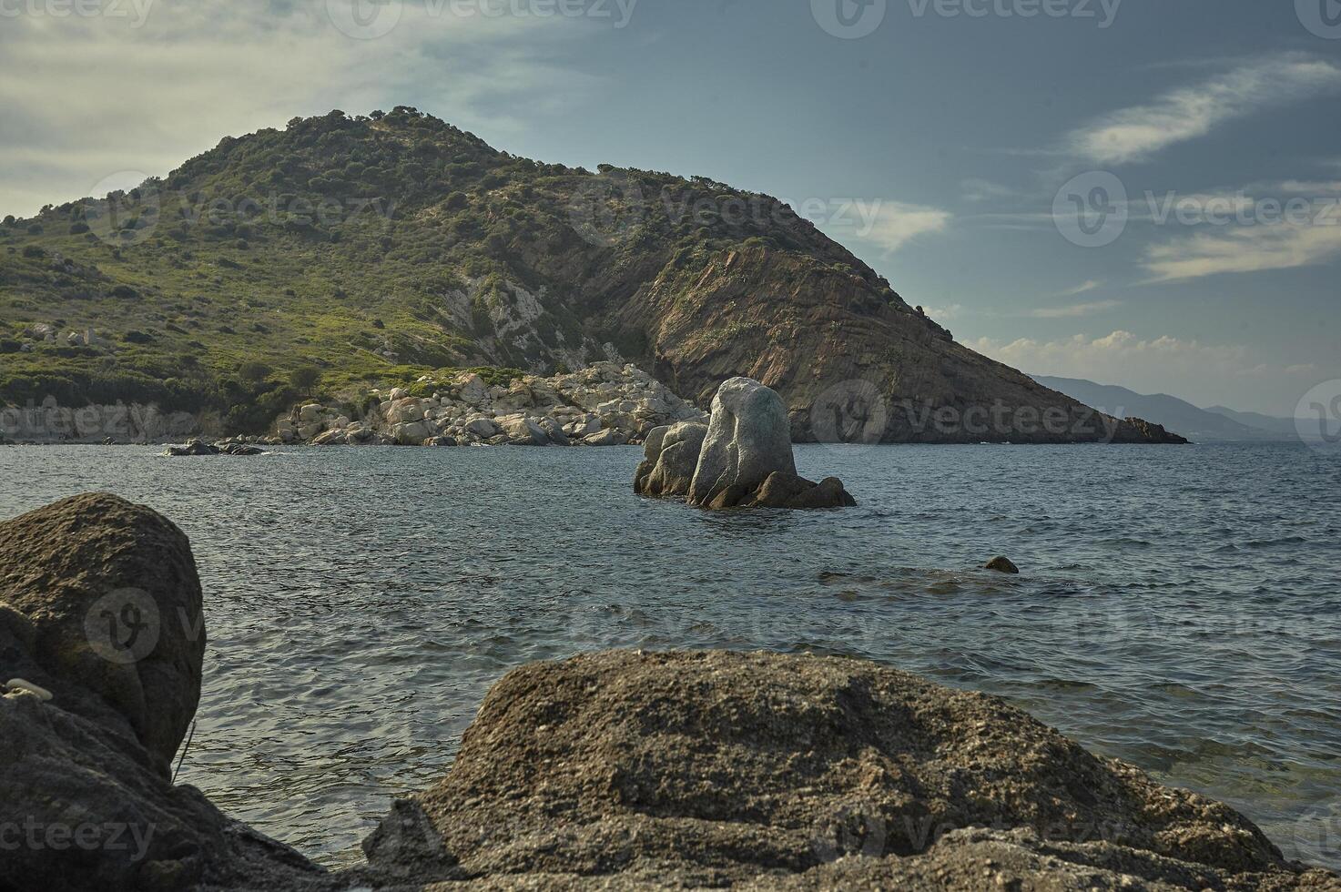 Rocks sprout from the sea in front of the natural precipice photo