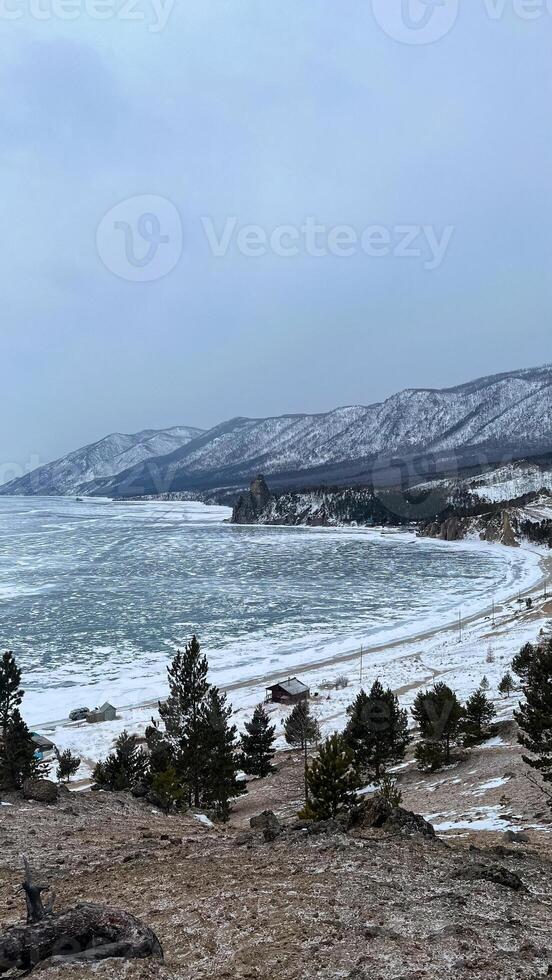 puesta de sol playa lago baikal con rocas frente y nieve el apuntalar baikal en invierno foto