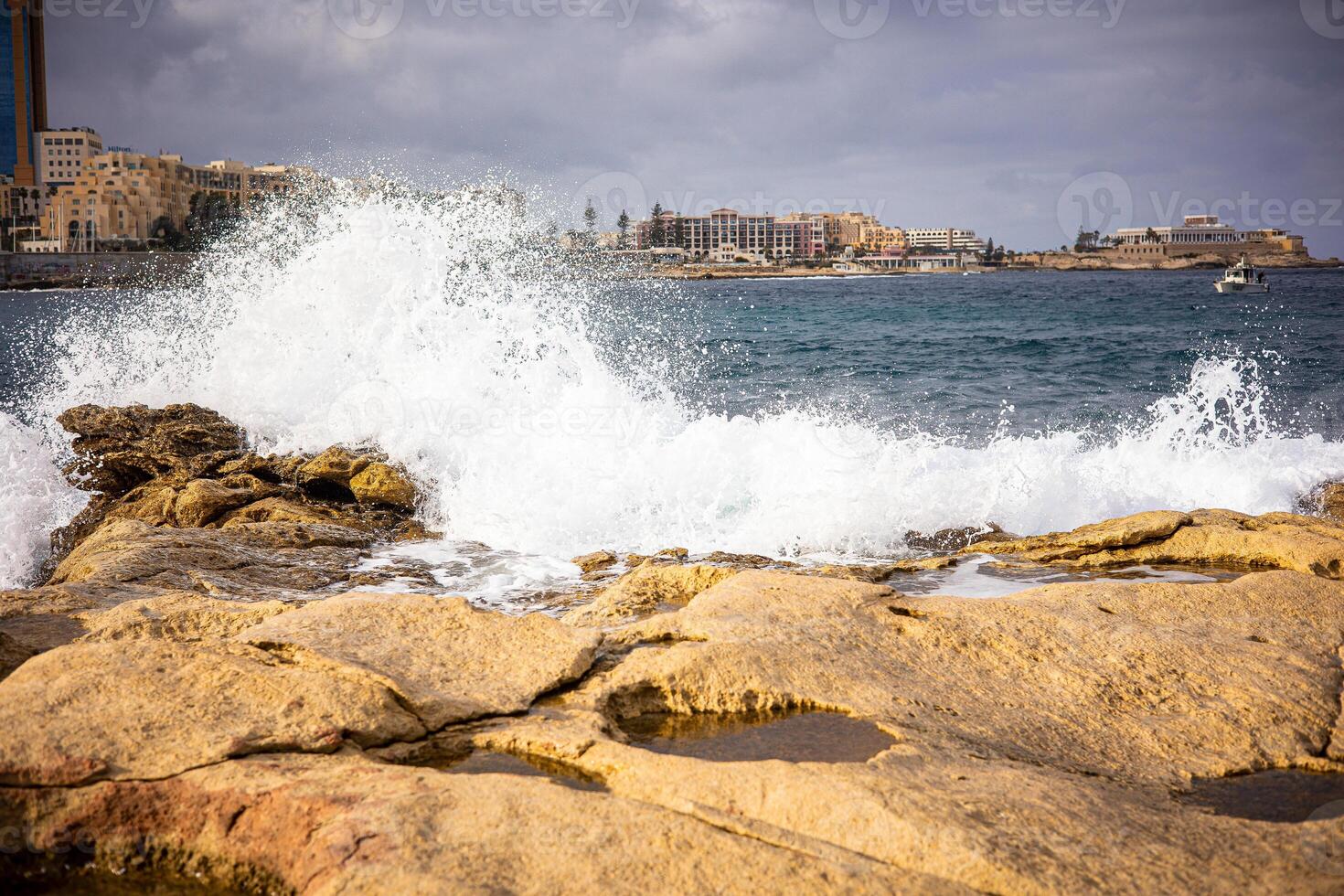 High waves of the ocean on a rocky shore. Coast of the island of Malta in winter photo