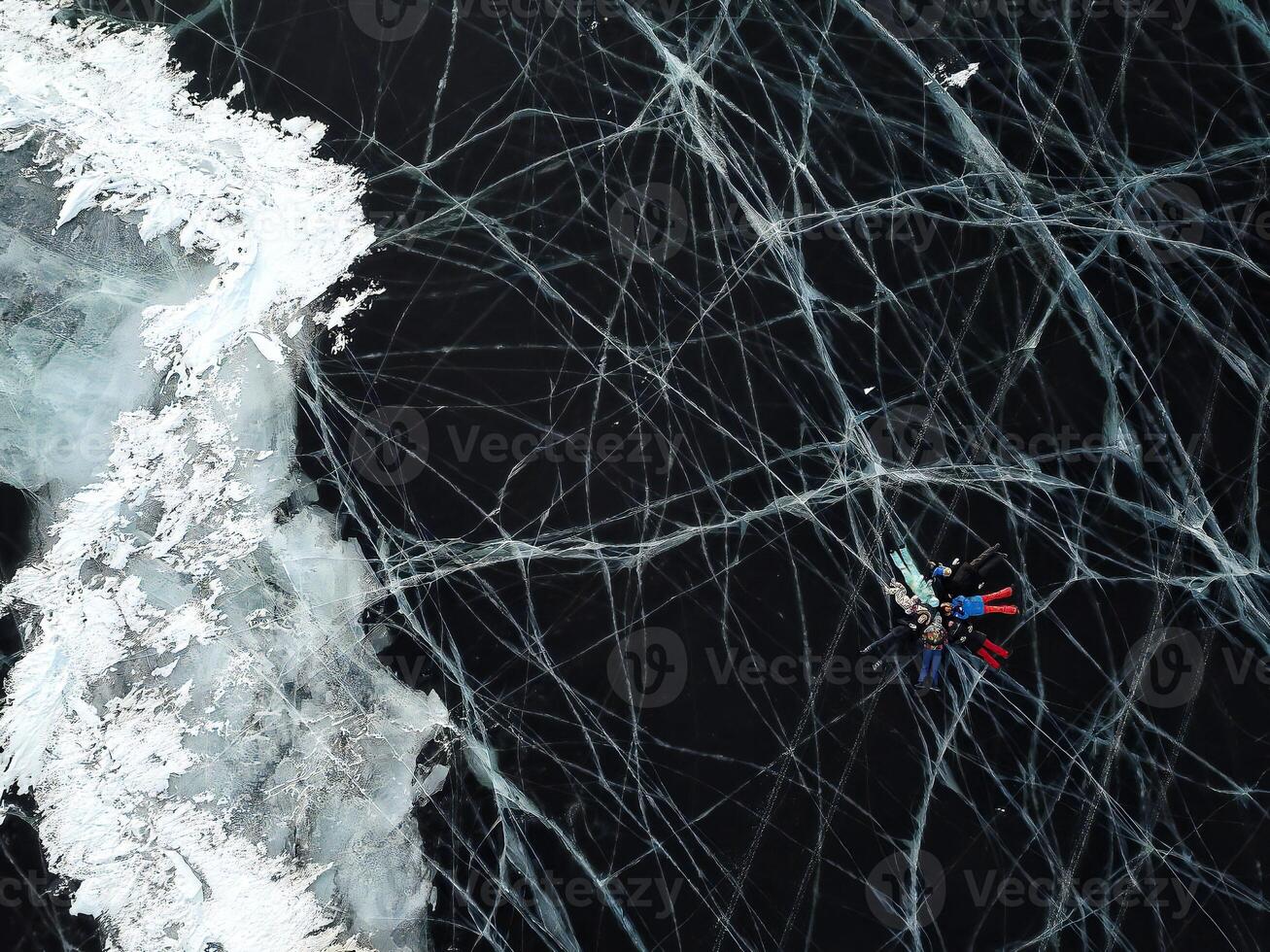From above, a view of the frozen ice of Lake Baikal group of tourists lie ice photo