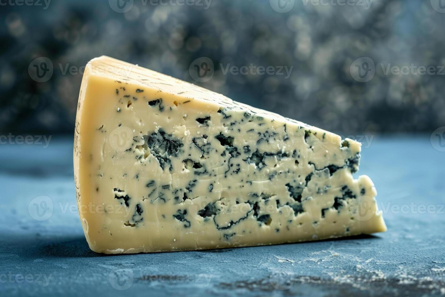 Wedge of Roquefort cheese with a bold blue to black gradient background, highlighting the intense blue veining of the cheese photo