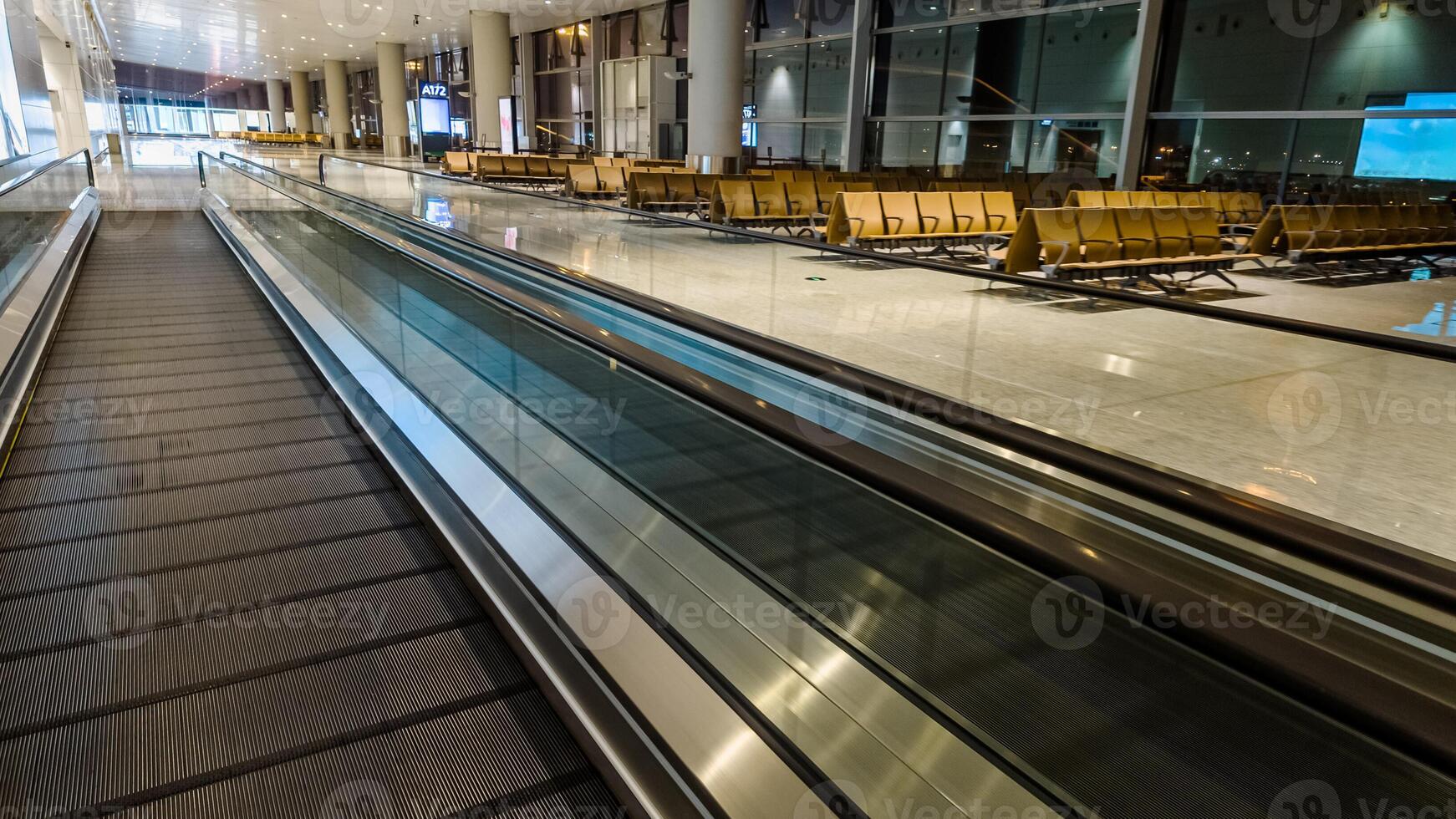 Empty airport terminal with a moving walkway and waiting area, showcasing modern travel infrastructure, suitable for business and holiday travel themes photo
