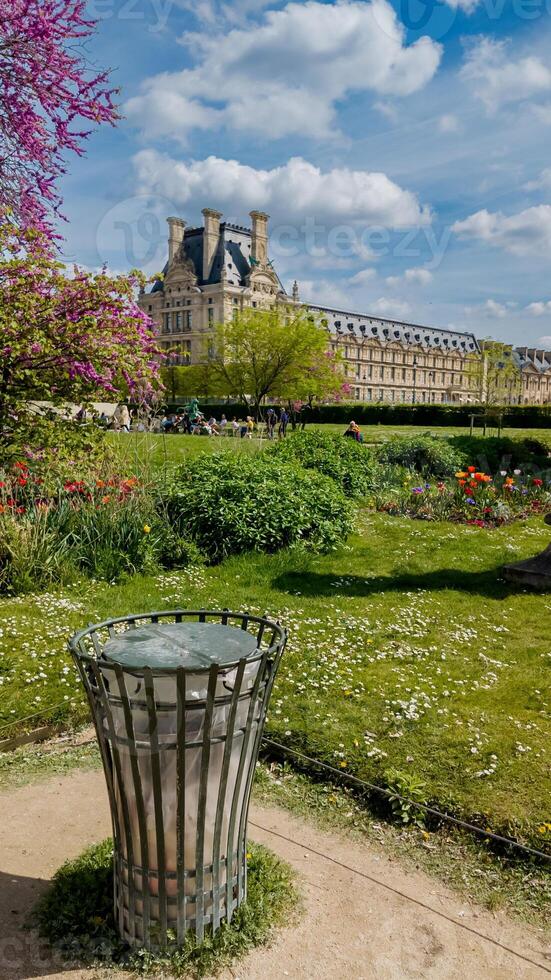 Springtime in Paris with a focus on a trash bin in the Tuileries Garden, showcasing environmental cleanliness and tourism, ideal for Earth Day promotions photo