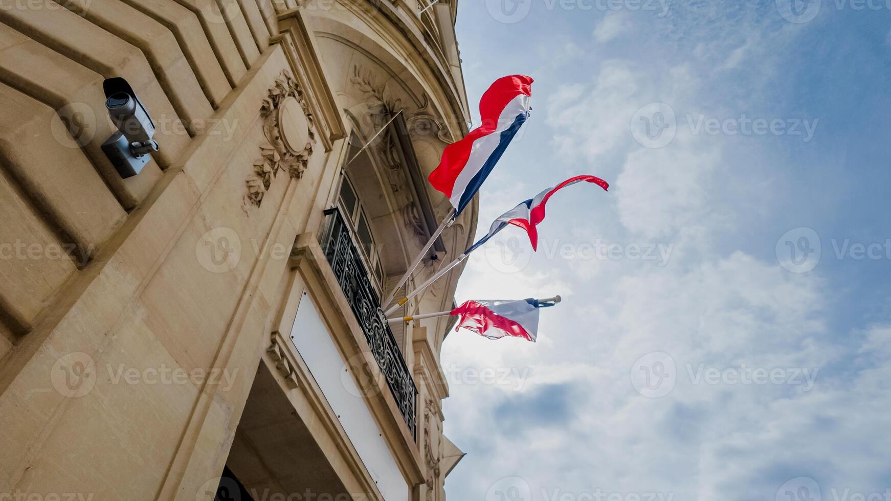 French and European Union flags fluttering against a blue sky on a government building, symbolizing Bastille Day and European unity, suitable for national celebrations photo