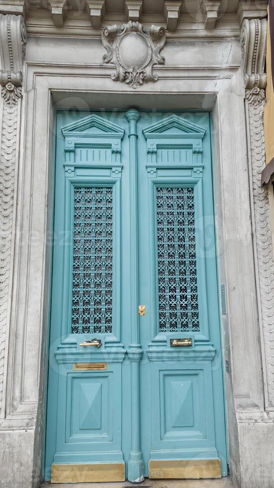 Elegant turquoise door with ornate metal grilles and classic moldings, ideal for historical architecture and home renovation concepts photo