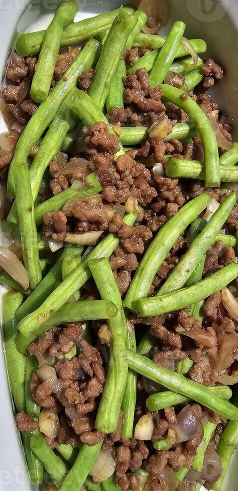 String green bean or french beans with minced beef stir fry or sauteed called Tumis buncis daging sapi cincang in Indonesia photo
