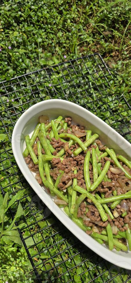 String green bean or french beans with minced beef stir fry or sauteed called Tumis buncis daging sapi cincang in Indonesia photo