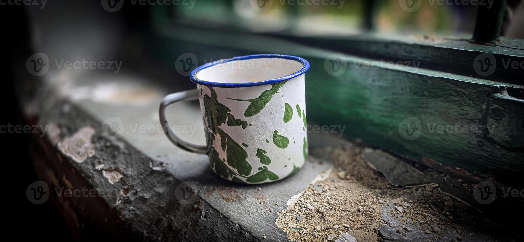 Ice chocolate drink on a vintage Indonesian iron mug with random green pattern called Blirik cup or cangkir Blirik on bokeh background along with chocolate filling bread photo