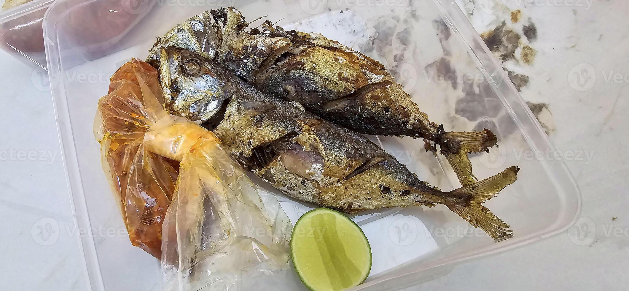 frito caballa servido con separar chile salsa y Lima, o llamado ikan kembung Goreng. ikan banear goreng con rica sambal foto