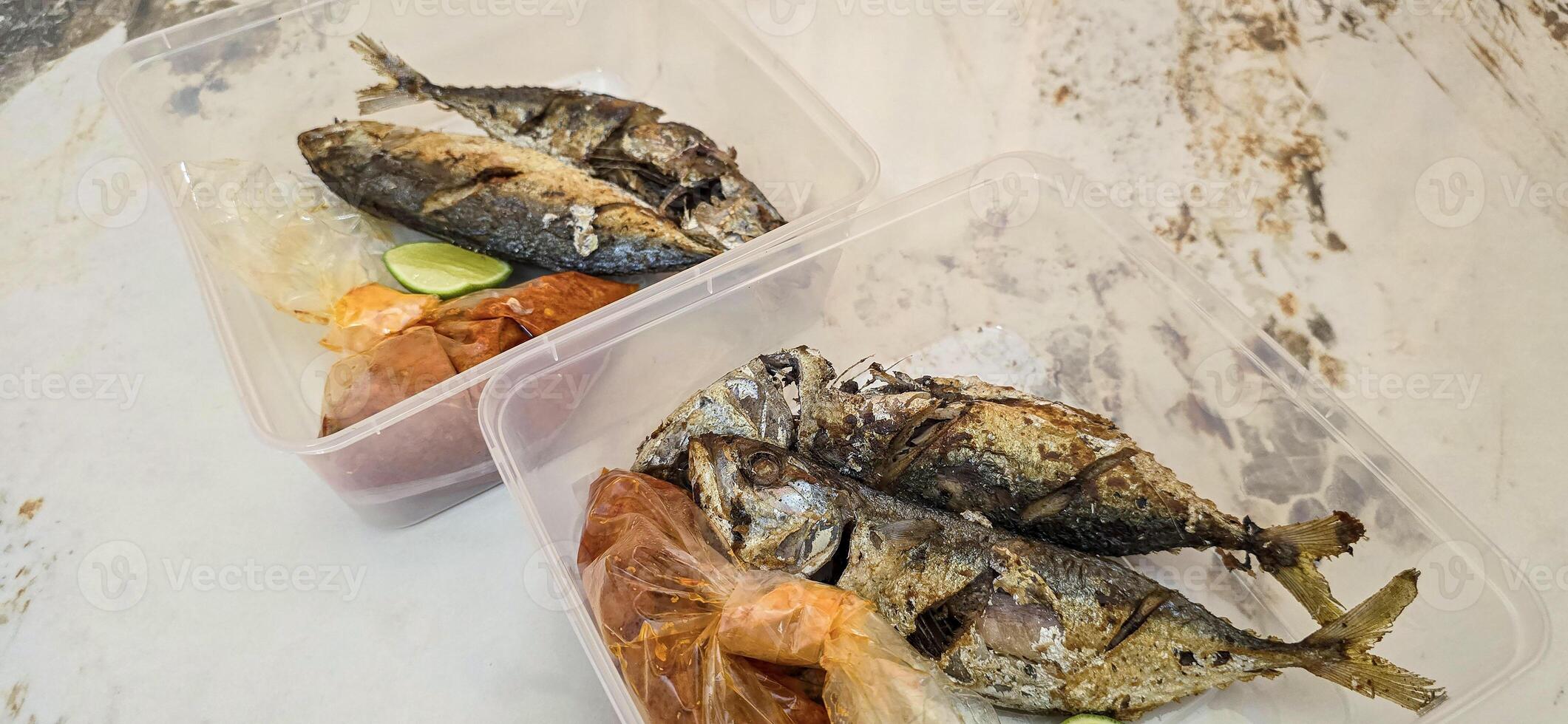 Fried Mackerel served with separate chili sauce and lime, or called Ikan kembung goreng. ikan banyar goreng with rica sambal photo