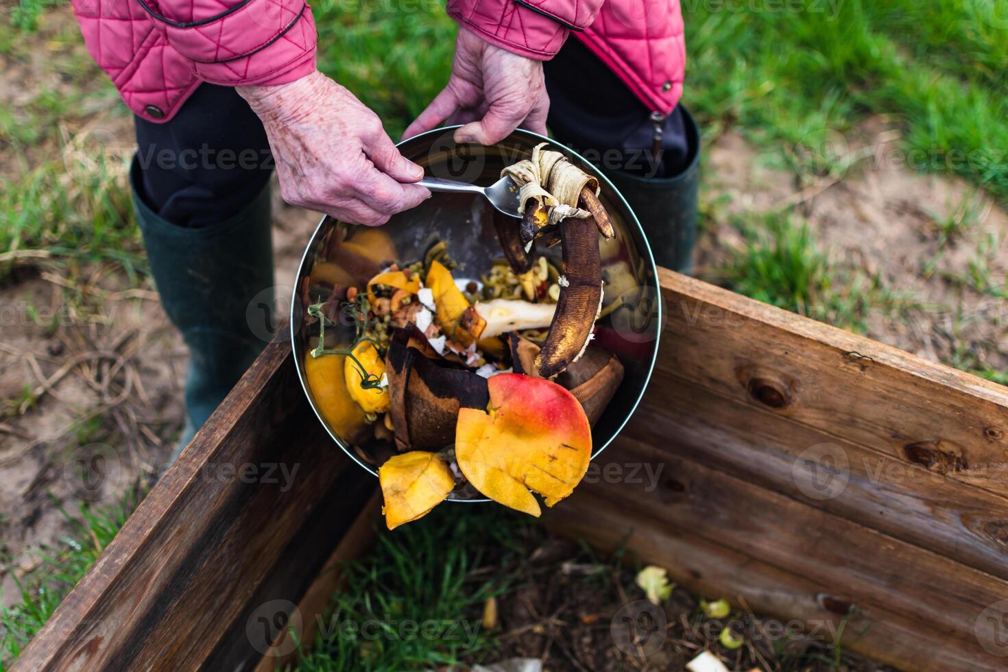 Person who put in a composter some kitchen waste like vegetables, fruits, eggshell, coffee grounds in order to sort and make bio fertilizer photo