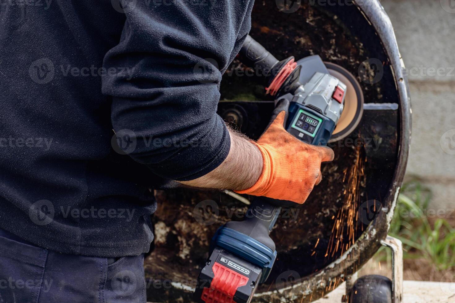 Man using portable grinder with sparkles photo