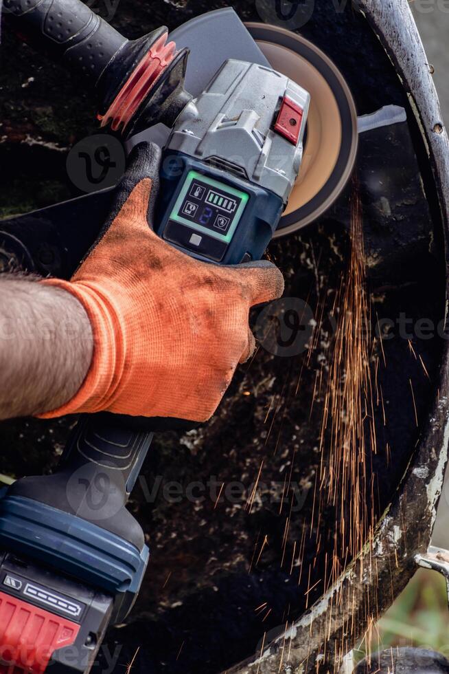 Man using portable grinder with sparkles photo