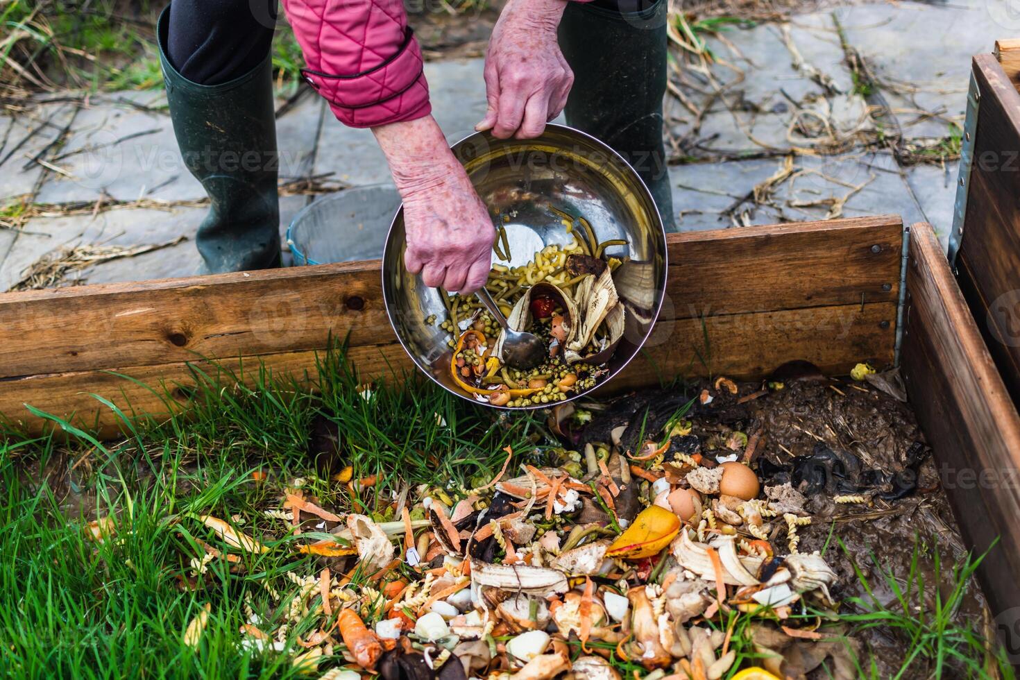 Person who put in a composter some kitchen waste like vegetables, fruits, eggshell, coffee grounds in order to sort and make bio fertilizer photo