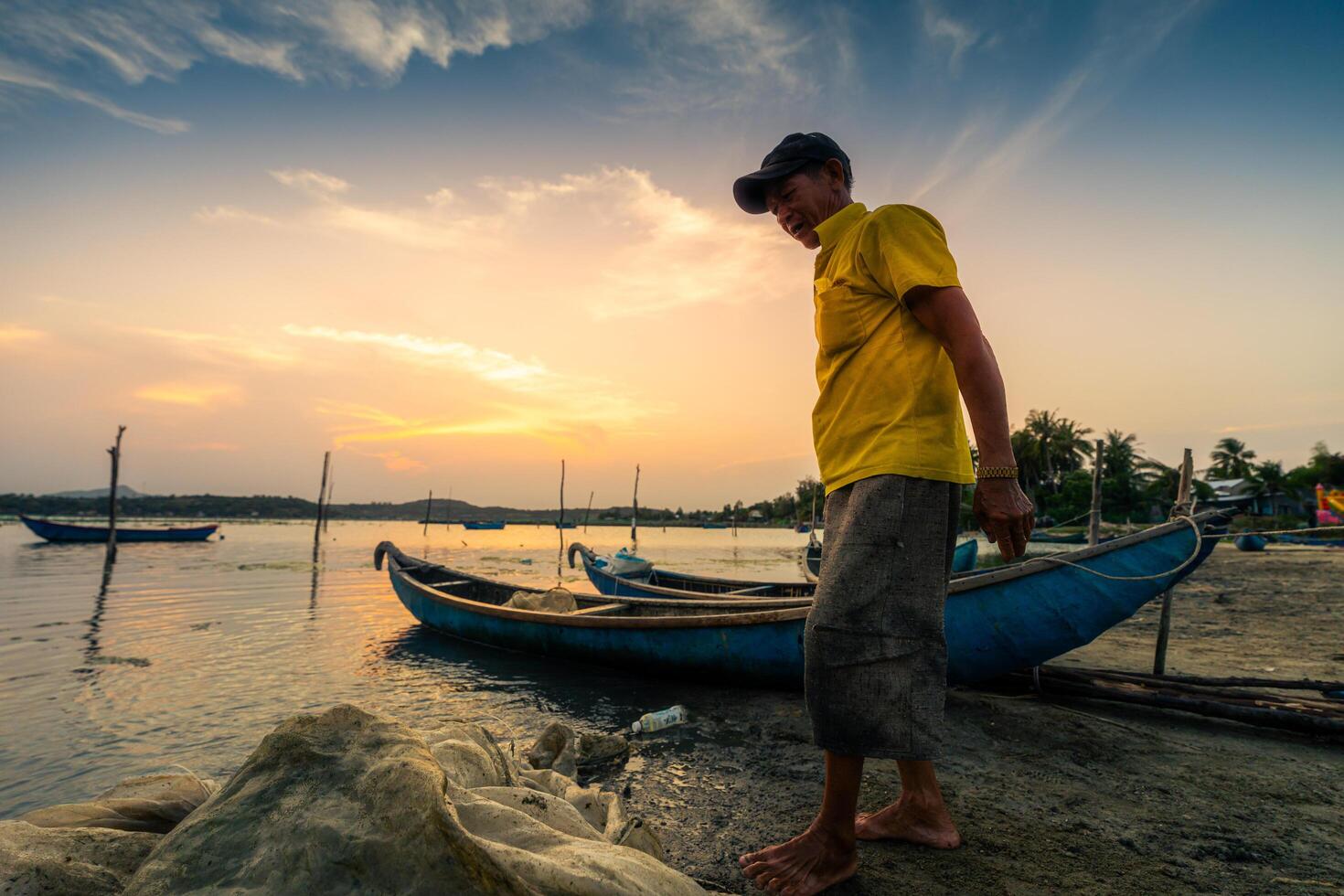 Traditional fishermen and boats in O Loan lagoon during sunset, Phu Yen province, Vietnam. Travel and landscape concept photo