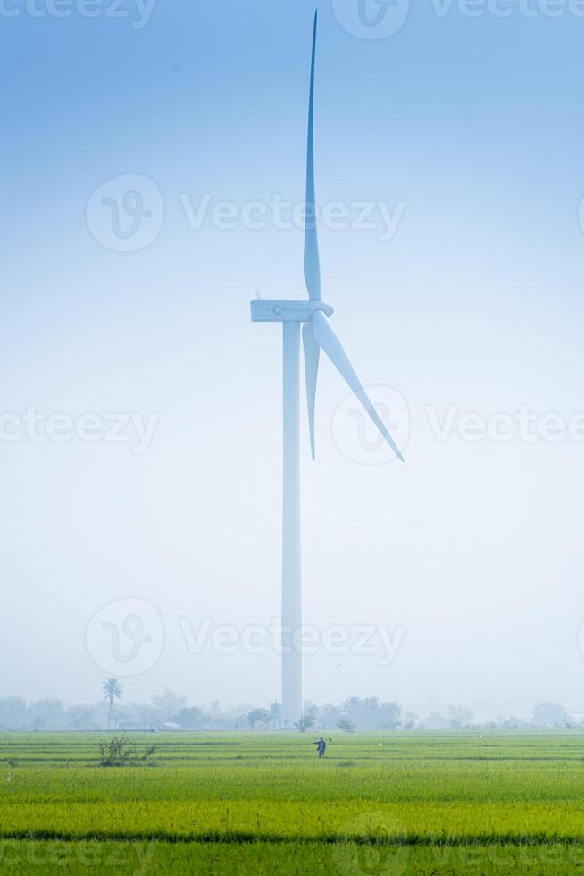 ver de turbina verde energía electricidad, molino para eléctrico poder producción, viento turbinas generando electricidad en arroz campo a phan sonó, ninh Thuan provincia, Vietnam foto