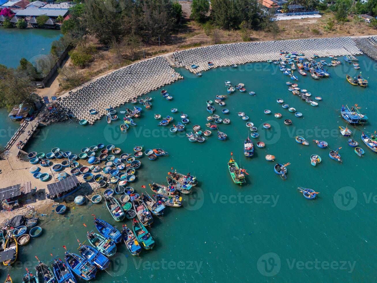 Aerial view of Loc An fishing village, Vung Tau city. A fishing port with tsunami protection concrete blocks. Cityscape and traditional boats in the sea. photo