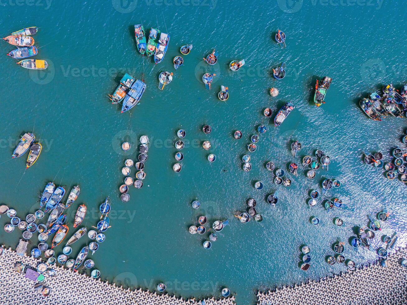 Aerial view of Loc An fishing village, Vung Tau city. A fishing port with tsunami protection concrete blocks. Cityscape and traditional boats in the sea. photo