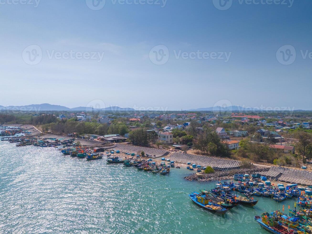 Aerial view of Loc An fishing village, Vung Tau city. A fishing port with tsunami protection concrete blocks. Cityscape and traditional boats in the sea. photo