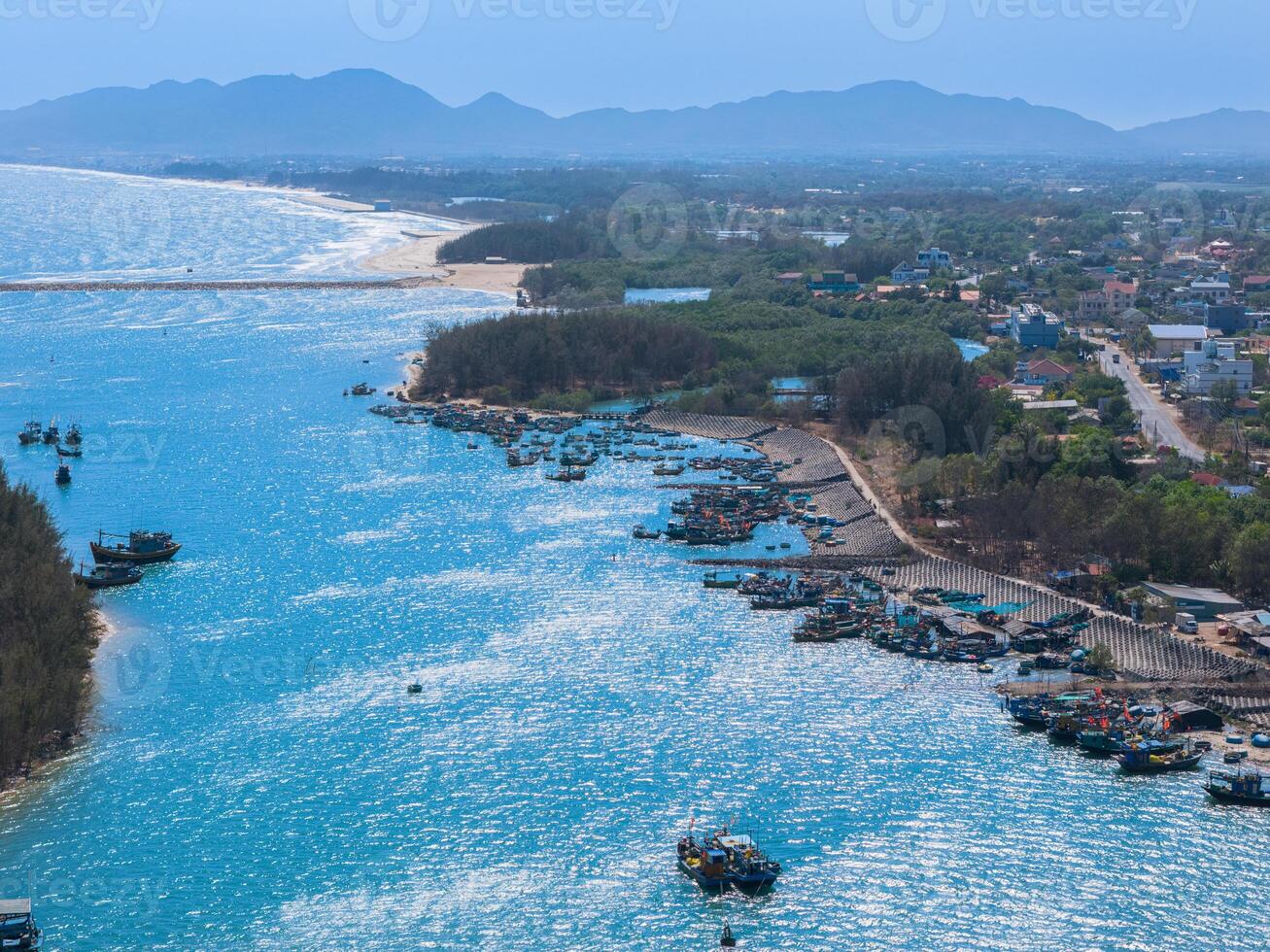 Aerial view of Loc An fishing village, Vung Tau city. A fishing port with tsunami protection concrete blocks. Cityscape and traditional boats in the sea. photo